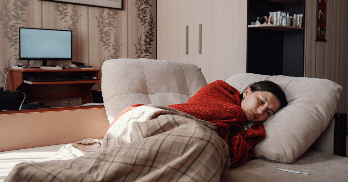 Woman resting on couch with blanket while sick with a cold | Sip2Sleep®