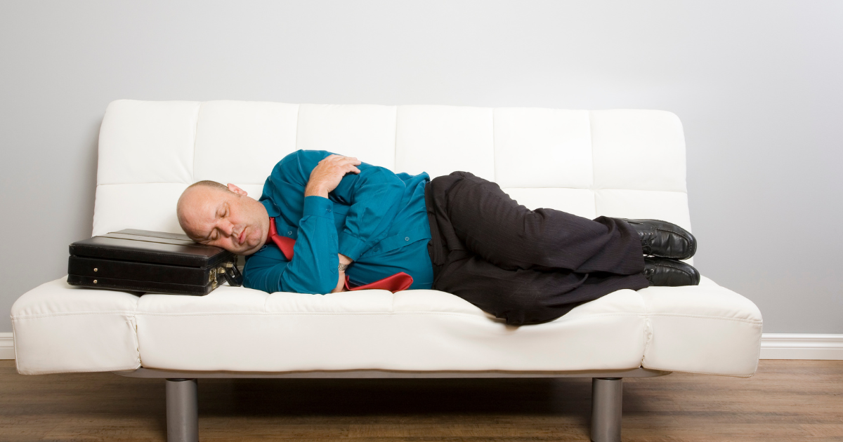 A man lying down on couch asleep