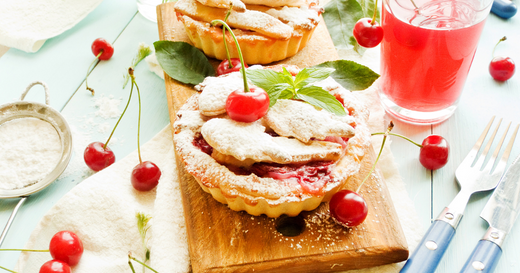 Two cherry tarts, fresh cherries, and a glass of cherry juice on a wooden surface | For Sleep