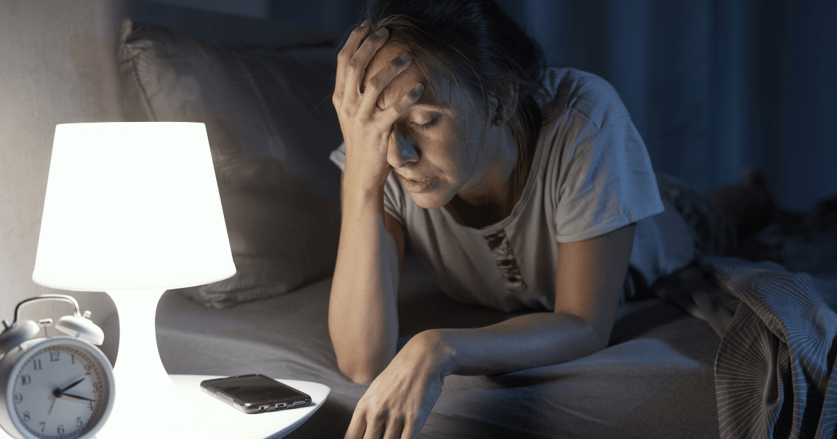 Women awake at 3 am, she cant sleep and she has a bad headache, insomnia and stress 