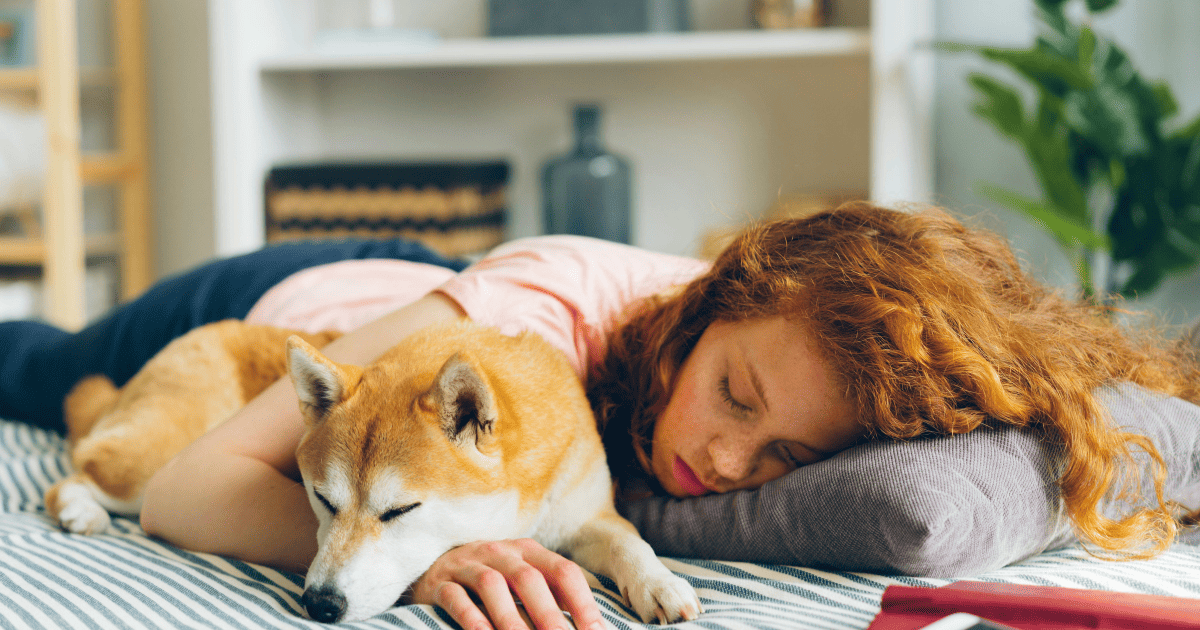 Women sleeping peacefully next to a dog, free from stress.