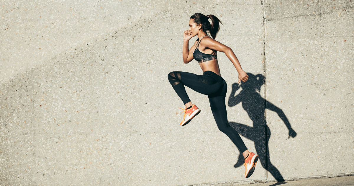  woman in athletic wear doing high-intensity exercise outdoors against a concrete wall | Sip2Sleep®